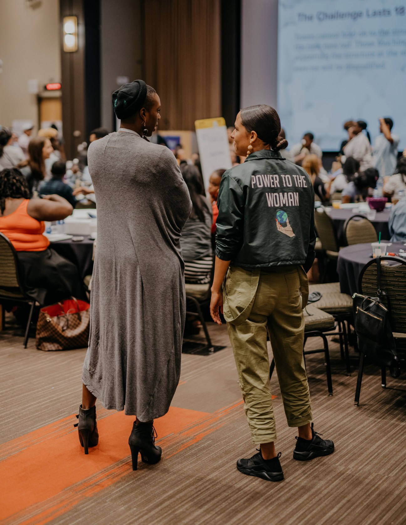 Two young people wearing casual clothing stand facing each other at the Obama Foundation Community Leadership Corps bootcamp held at DePaul University.
