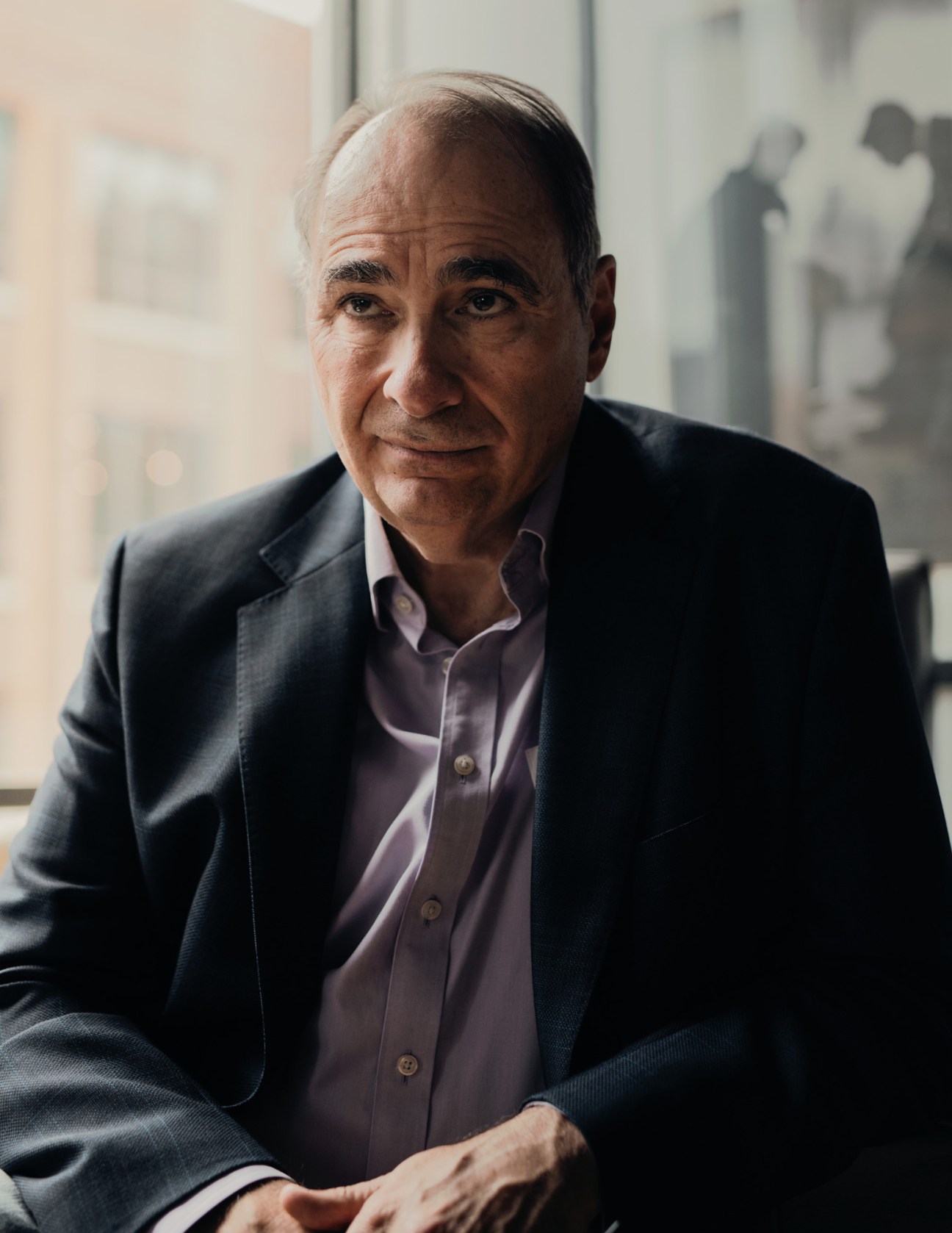 David Axelrod, Obama's long-time strategist, seated by a window in an office setting.