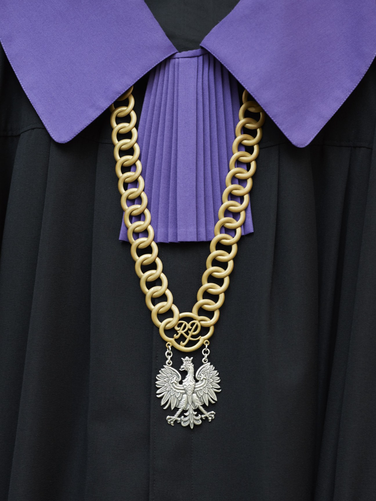 Polish Supreme Court judge regalia with purple collar, gold chain necklace, and silver eagle pendant on black robe.