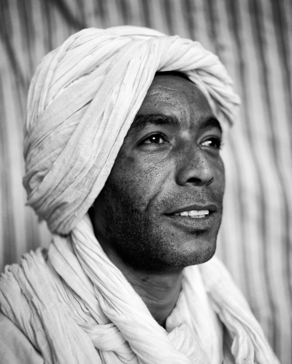 Black and white portrait of Hicham Salamat wearing a white turban in Tamnougalt, Morocco.