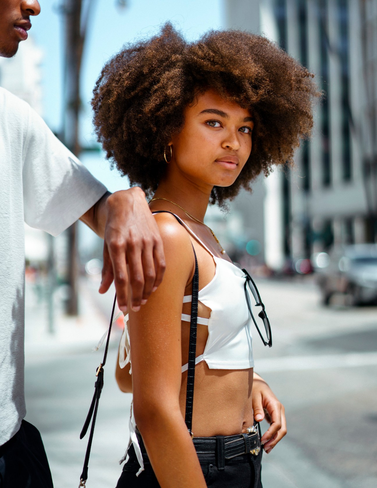 Woman with natural curly afro hairstyle and side part on a Los Angeles street.