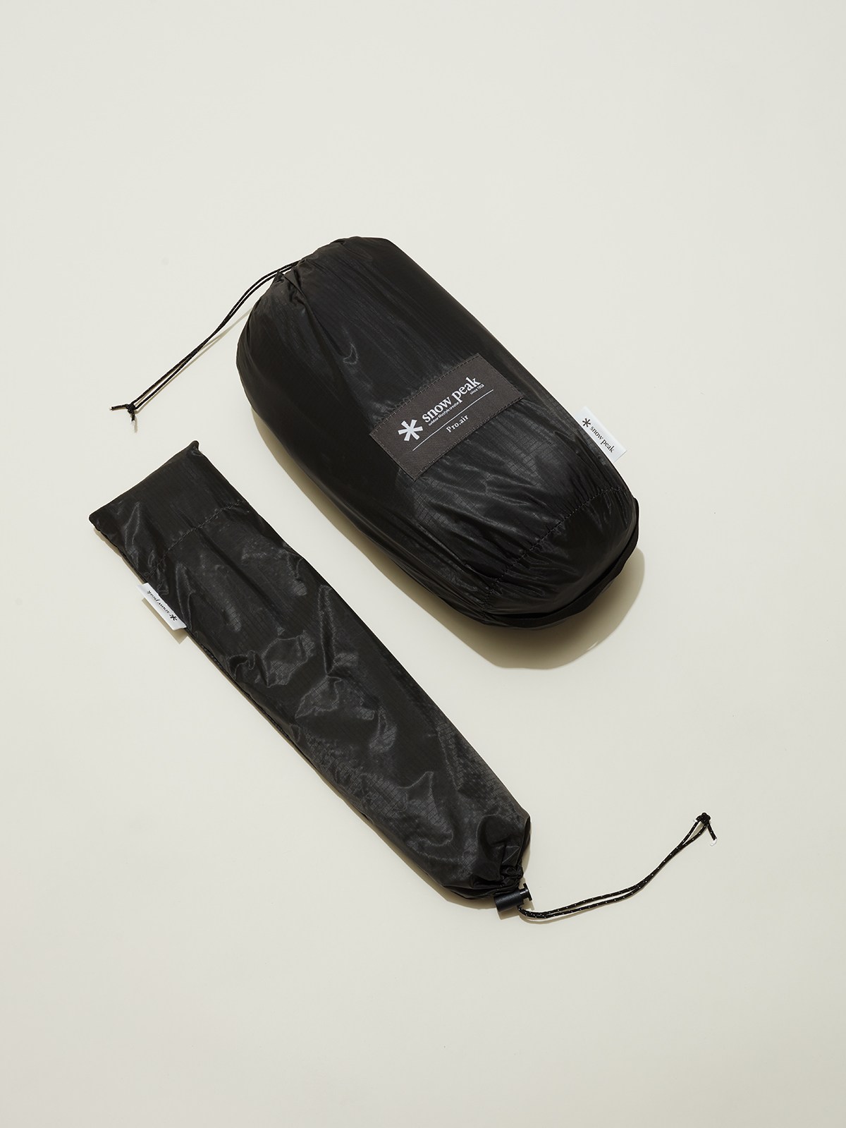 Black packaged tent components with drawstring storage bags and Snow Peak branding label