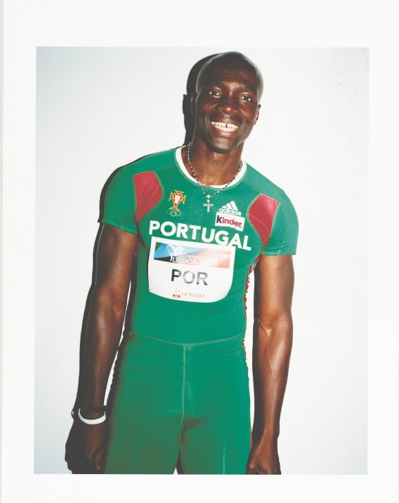 Portuguese sprinter and long jumper in green Portugal tracksuit with Kinder sponsor logo.