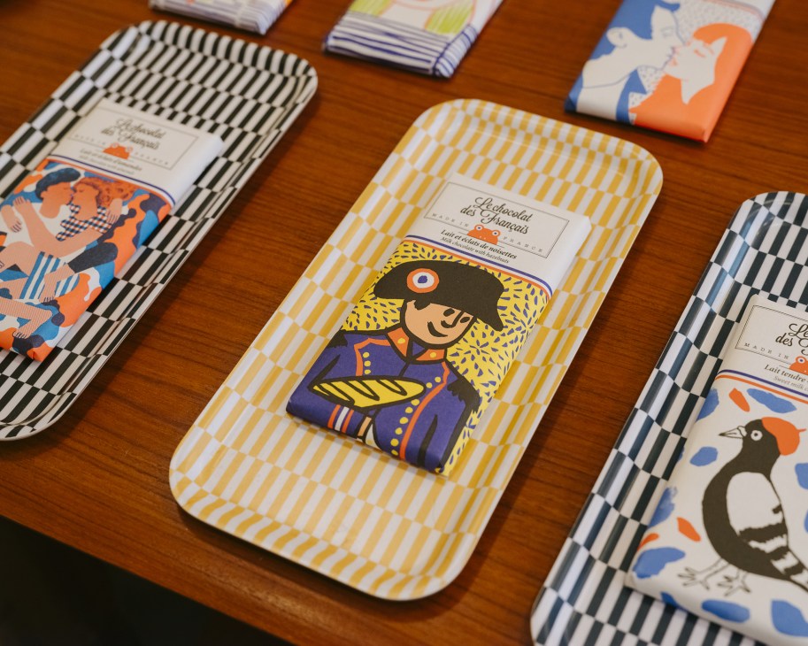 Colorful packaged chocolates with geometric patterns displayed on a wooden surface.