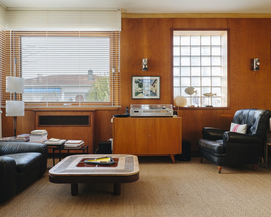 Mid-century modern living room with wood paneling, leather seating, and vintage furnishings at Villa Mirabelle in Royan.