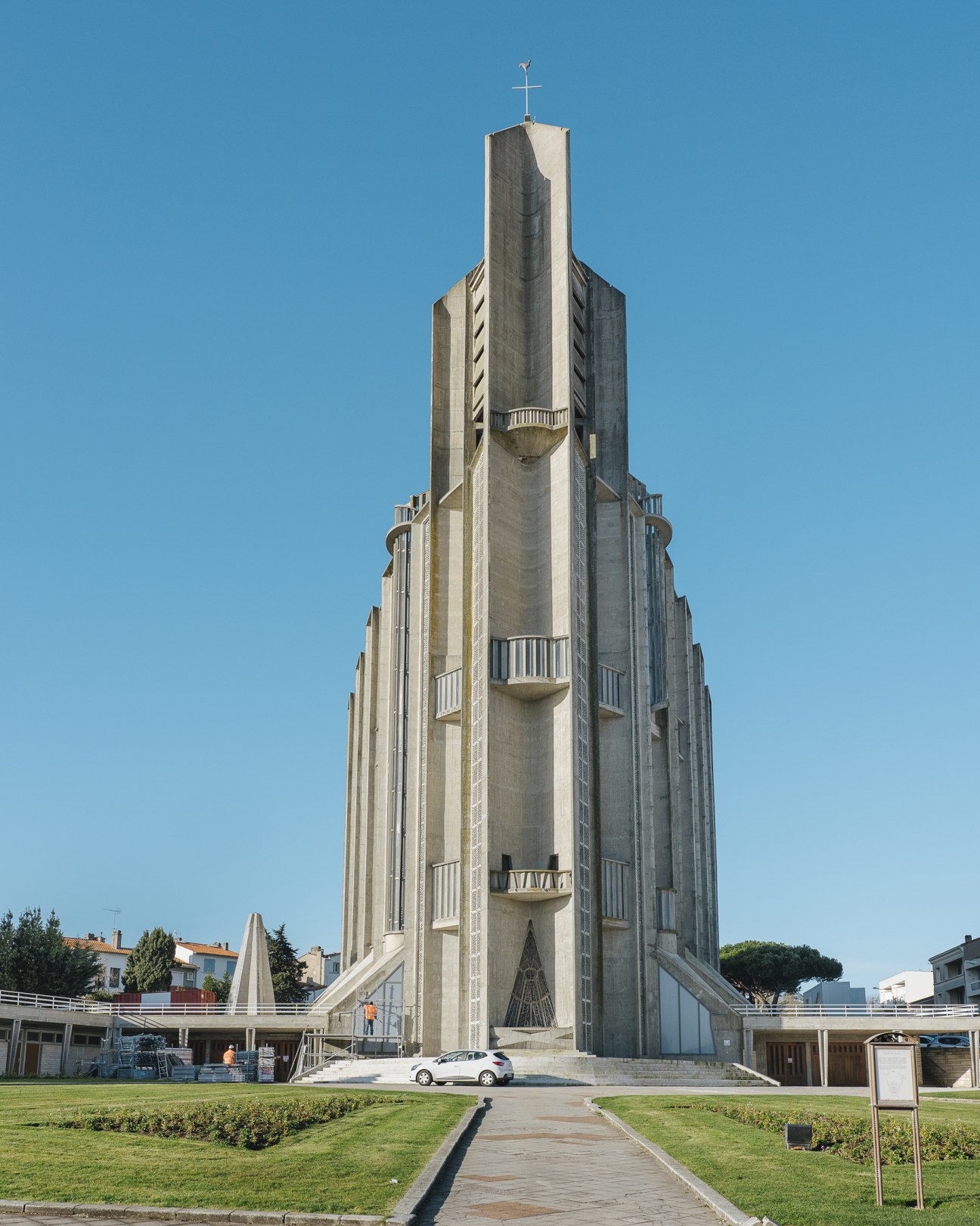 Église Notre-Dame, a brutalist concrete church tower with a cross on top, set against a clear blue sky in Royan.