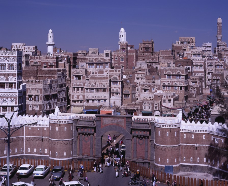 Aerial view of Yemen's old city with traditional multi-story buildings and fortified walls.