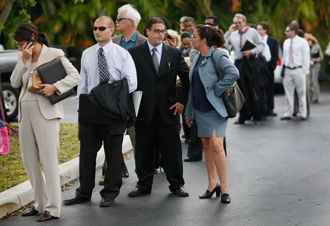 Business professionals in formal attire walking outdoors on a residential street.