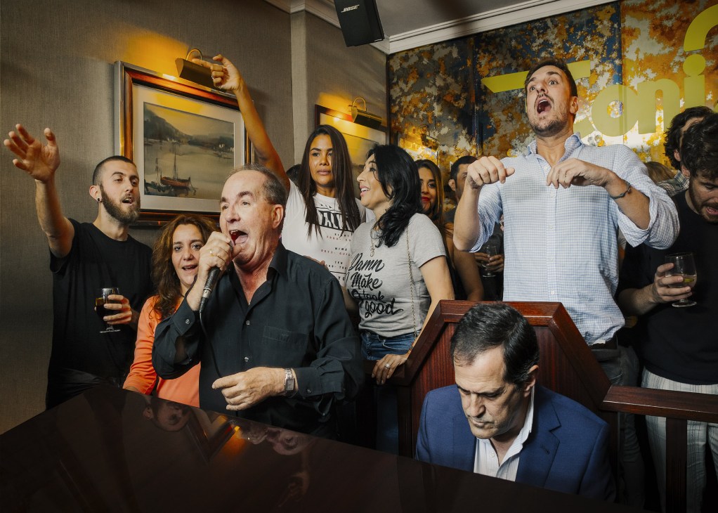 Guests singing together around a grand piano at Toni2 piano bar in Madrid
