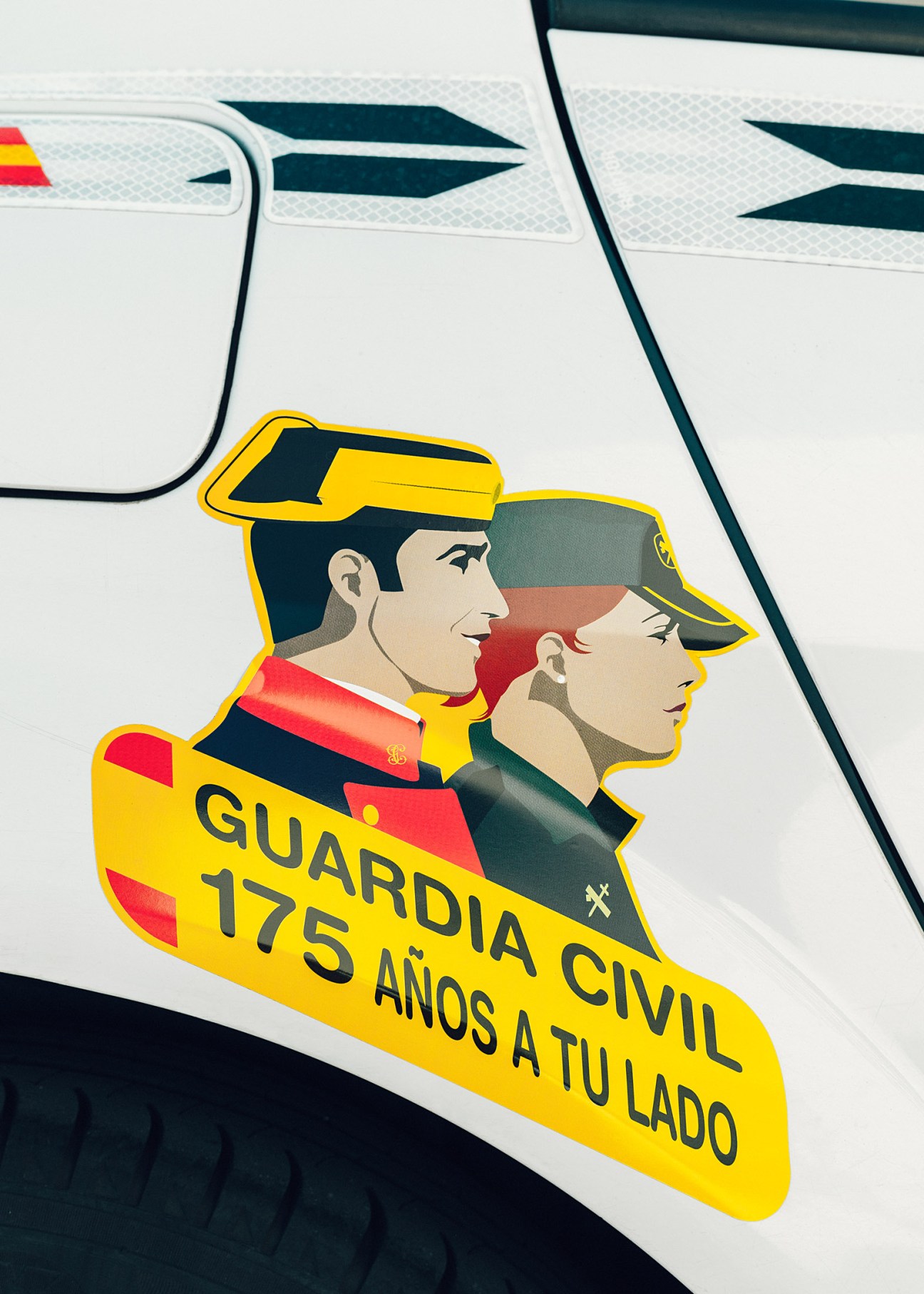 Guardia Civil anniversary emblem on vehicle showing two uniformed officers wearing tricornios with text '175 años a tu lado'