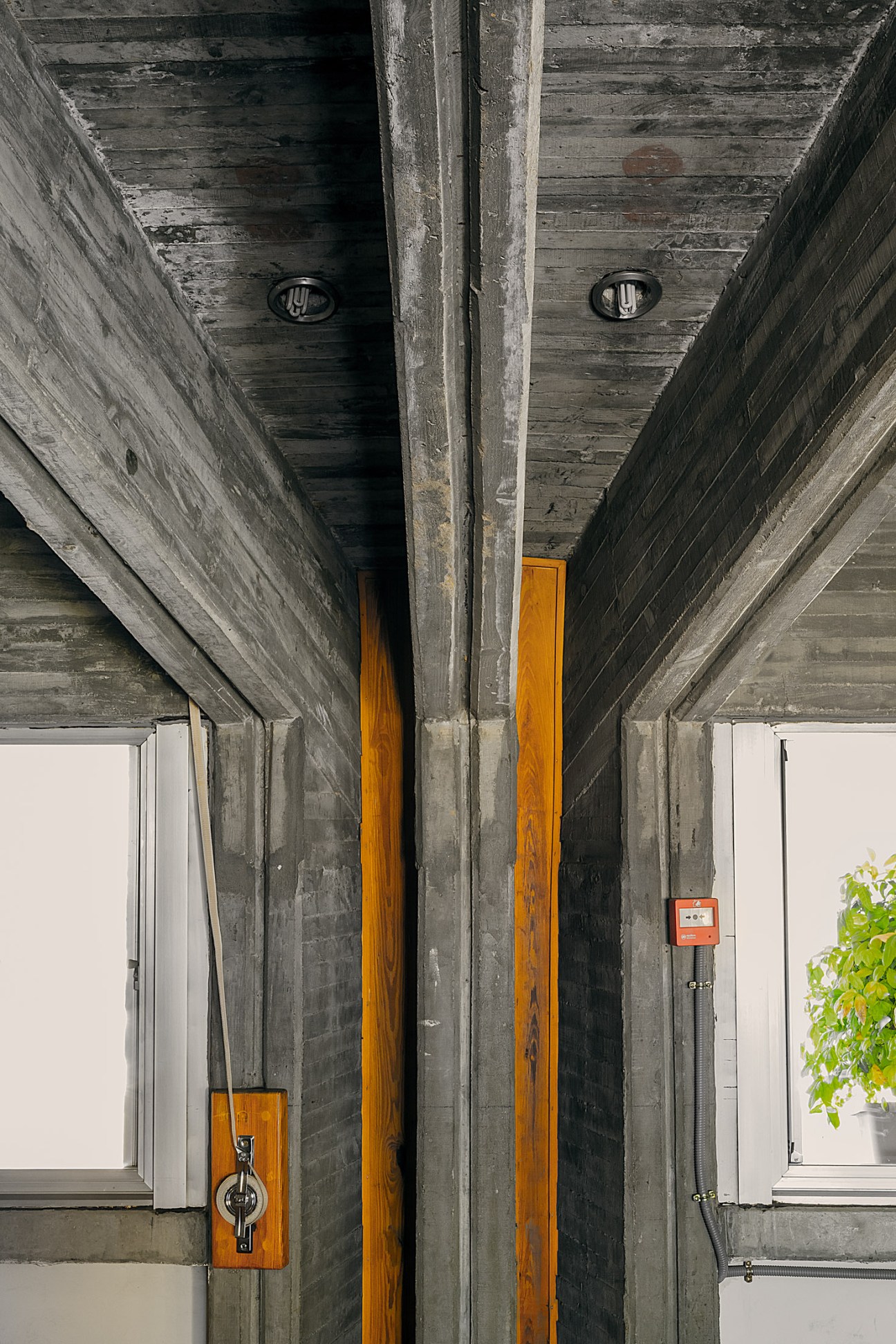 Brutalist concrete corridor with wooden doors and architectural details at Colegio Estudio.