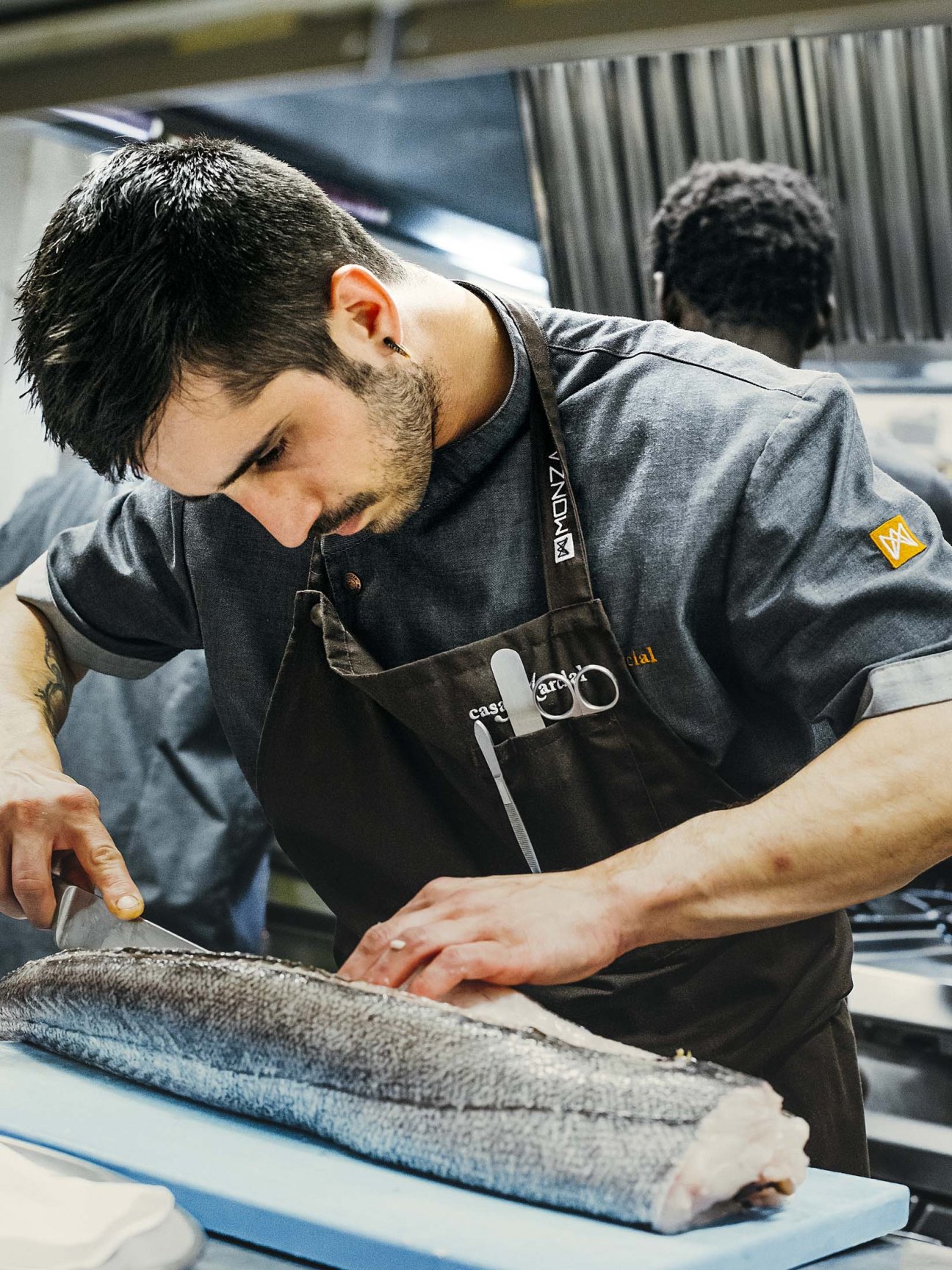 Chef Nacho Manzano preparing fish at Casa Marcial restaurant kitchen.