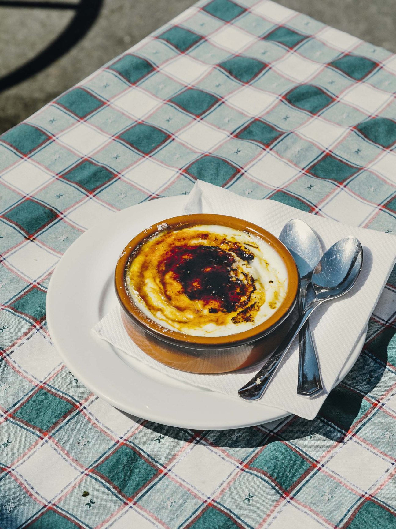Flambé rice pudding served in a wooden bowl on a checkered tablecloth at La Tortuga restaurant