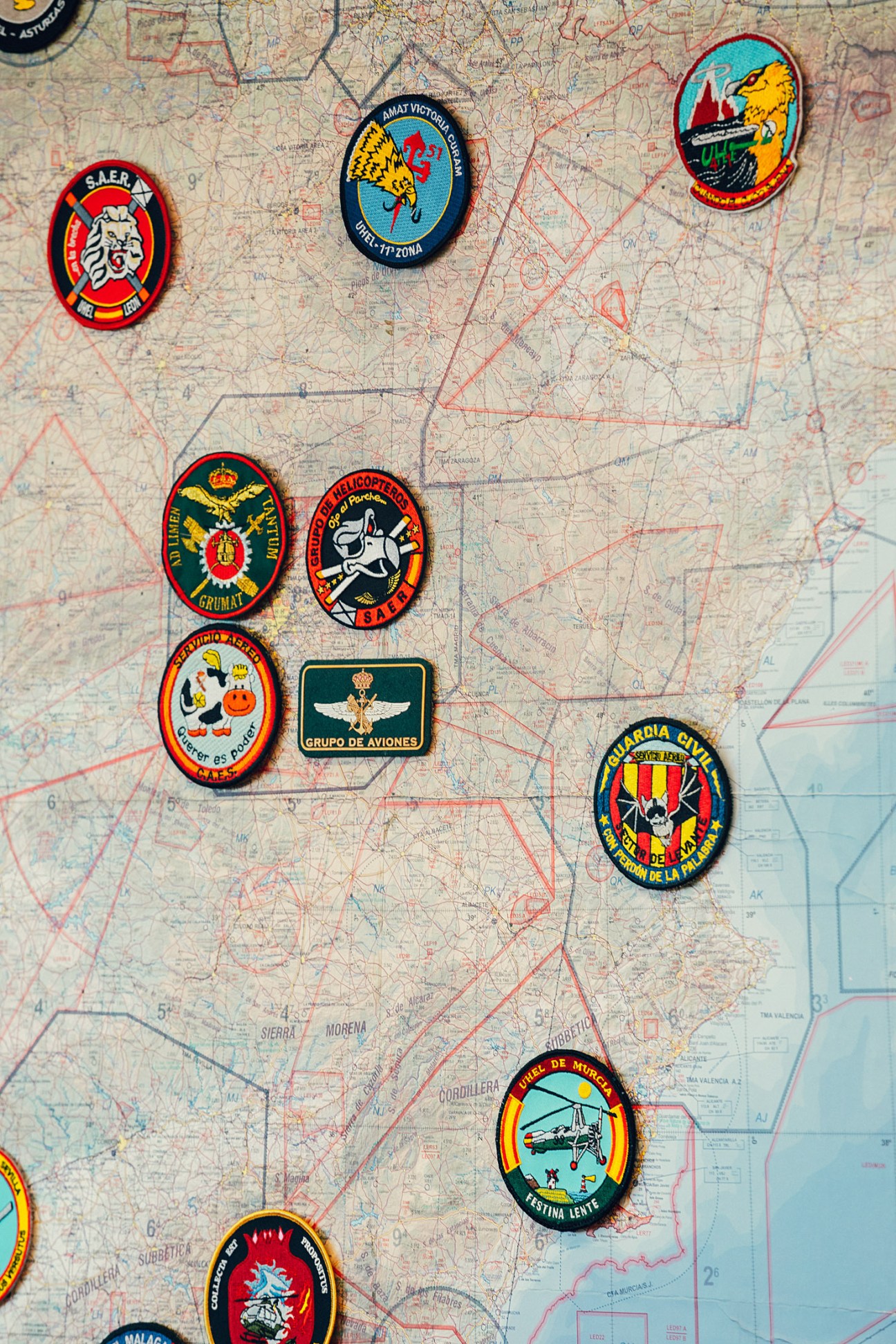 Military unit patches displayed on a map of Spain showing Guardia Civil air service base locations.