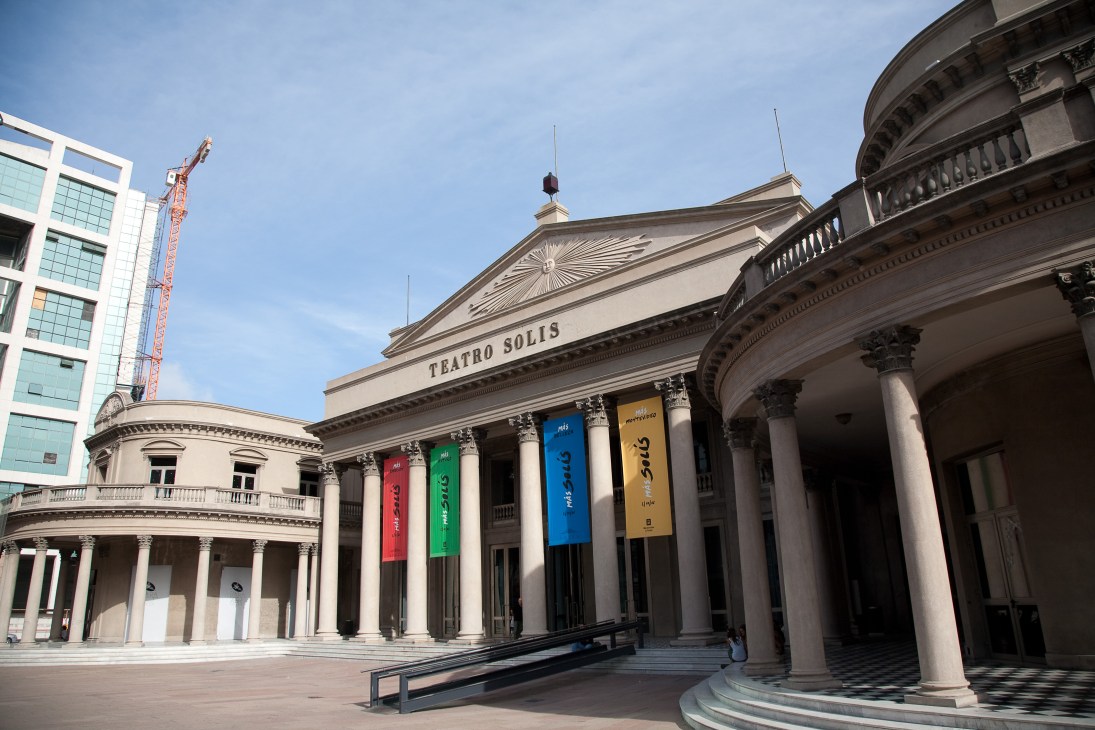 Teatro Solís, a neoclassical theater with white columns and colorful banners, in Montevideo.