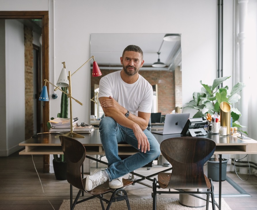 Alexandre Mattiussi sits at his desk in his bright office at Ami headquarters, wearing white trainers and a white t-shirt.