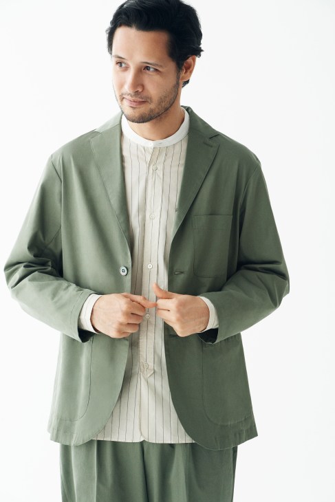 Man wearing a sage green jacket by Phlannèl with striped shirt by Still By Hand and matching trousers.