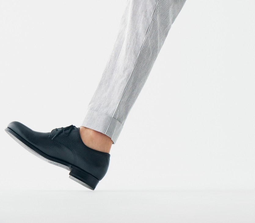 Person wearing striped trousers and black leather shoes by Martegani.