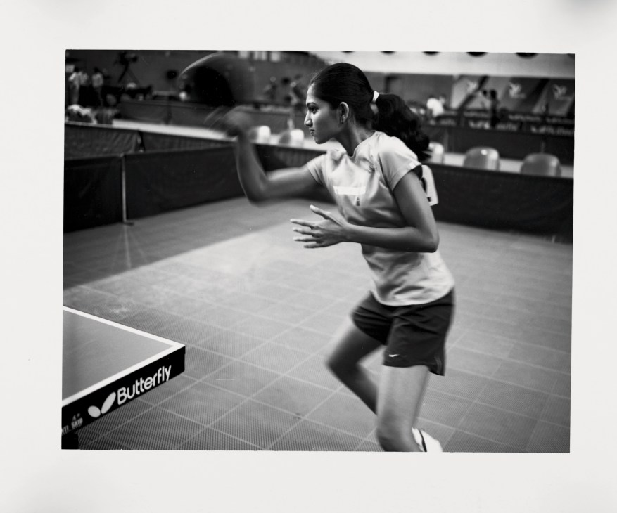 Woman playing table tennis at indoor facility with Butterfly-branded table