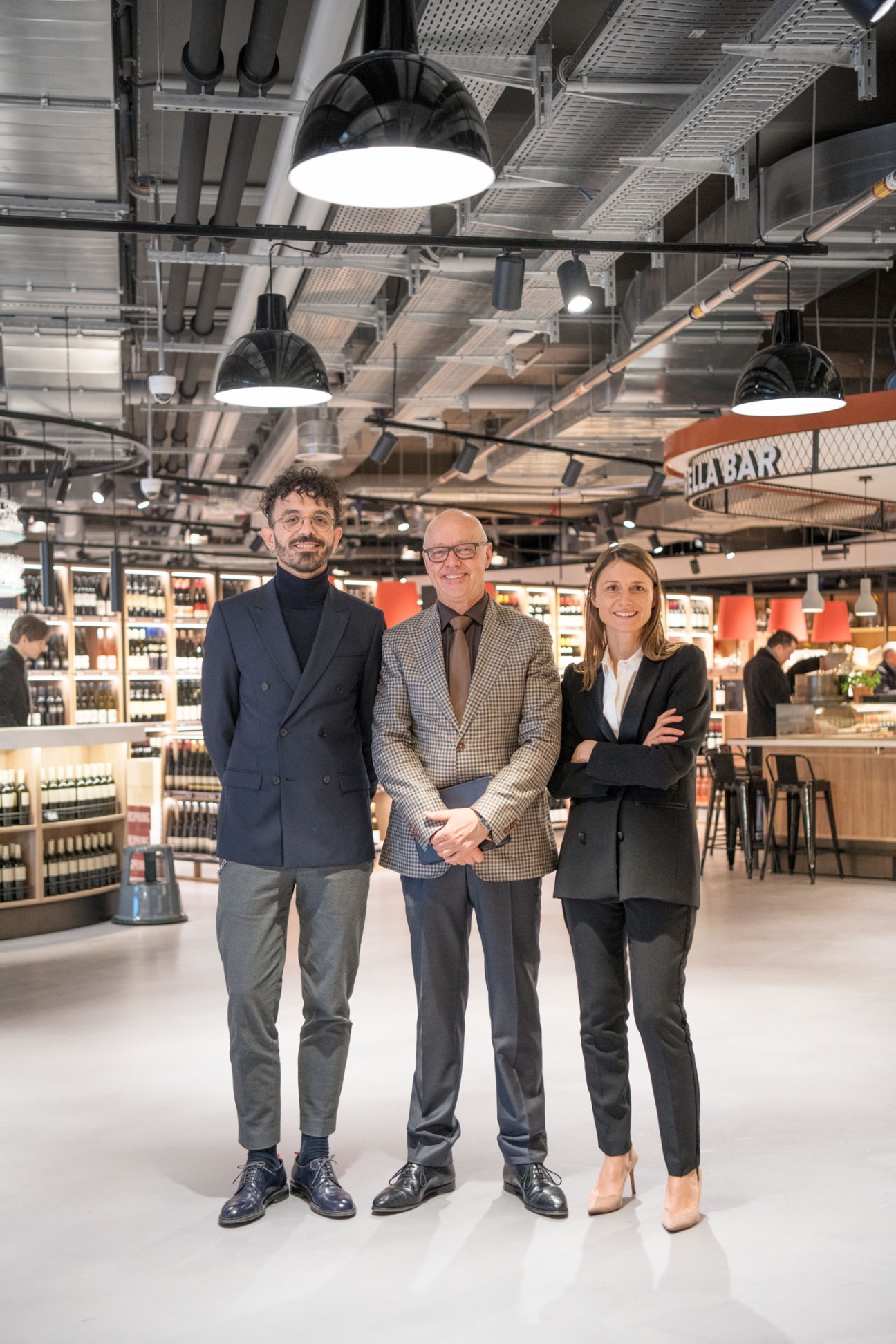 Luca Viglianti, Heinz Zurheide and Ruth Toechterle stand in the Zurheide supermarket interior.