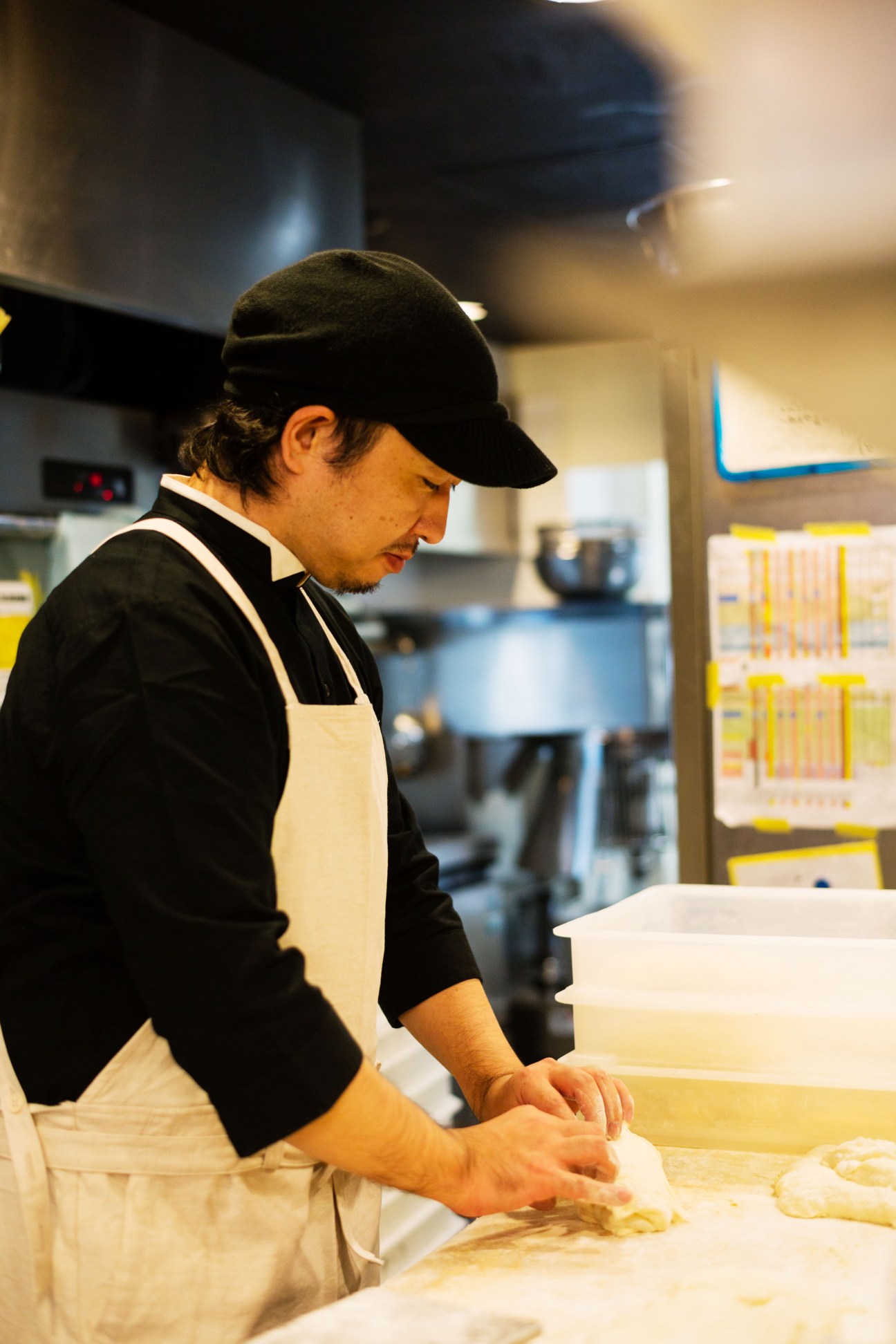 Baker Akimasa Sugikubo working with dough at 365 Nichi bakery in Tokyo.