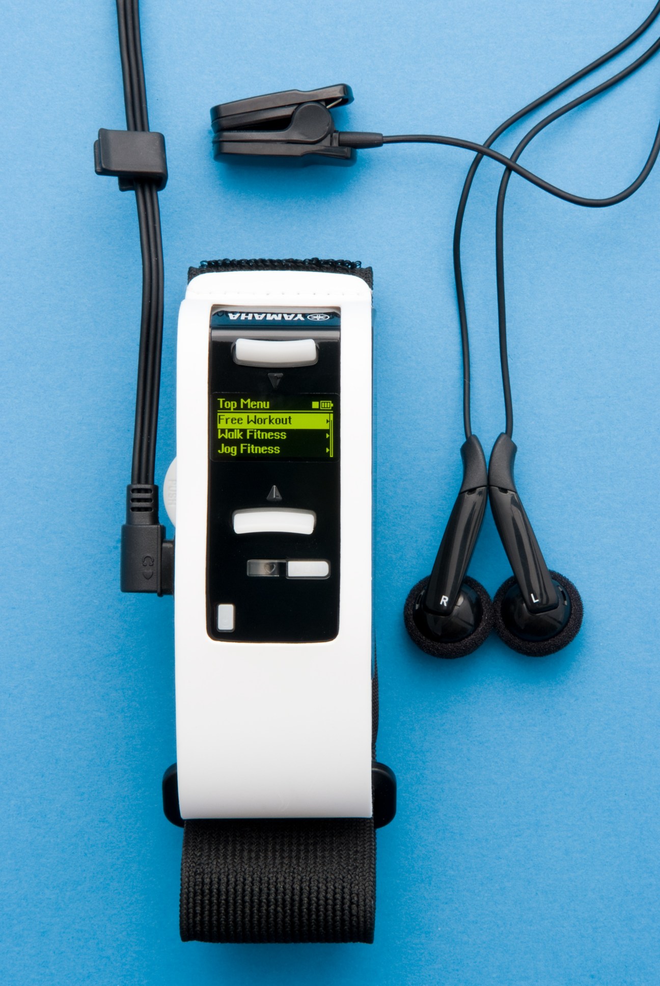 Yamaha Bodibeat music player with heart rate monitor, earbuds and armband on blue background.