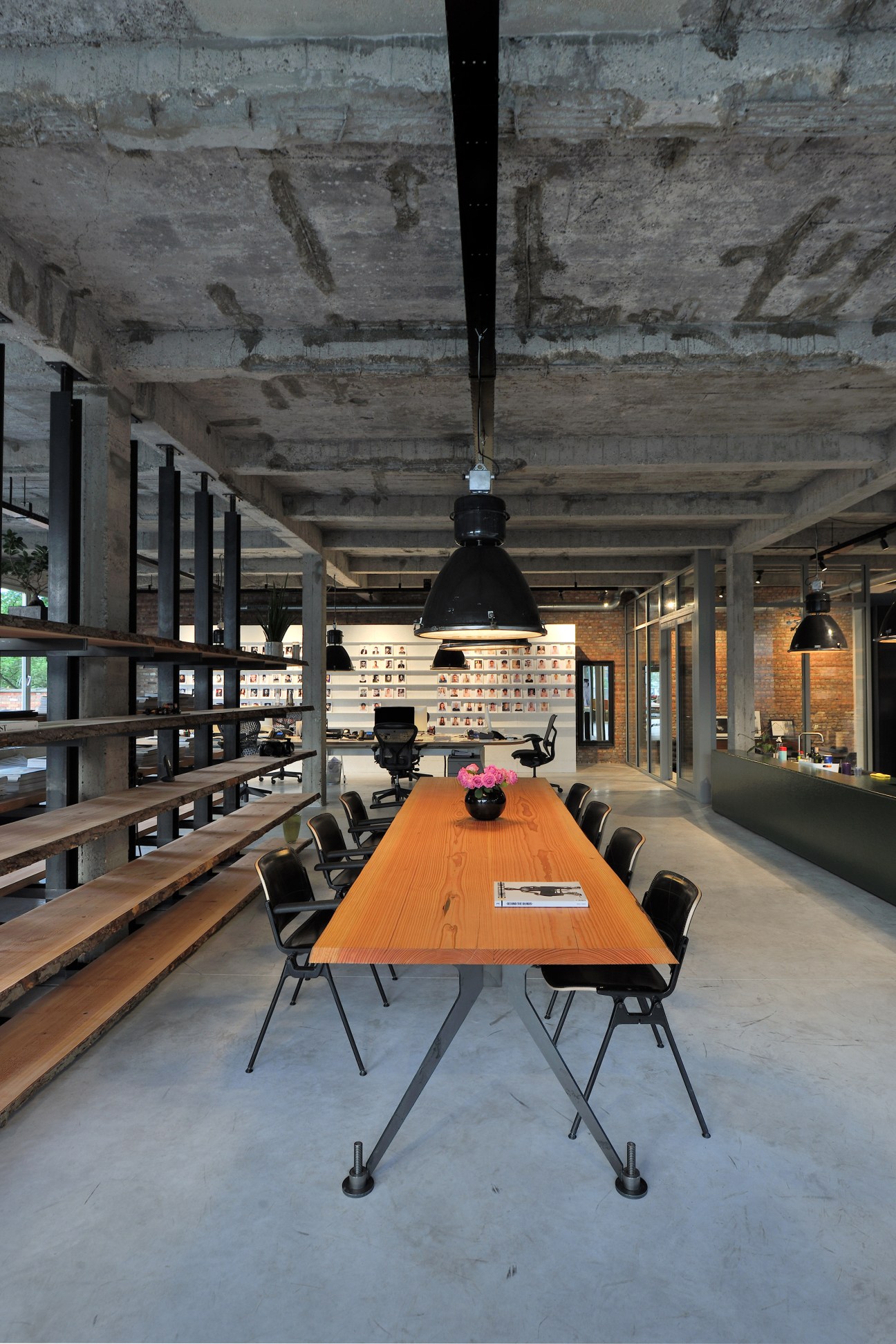 Modern office interior with wooden conference table, black chairs, and industrial ceiling at Ulla Models agency.