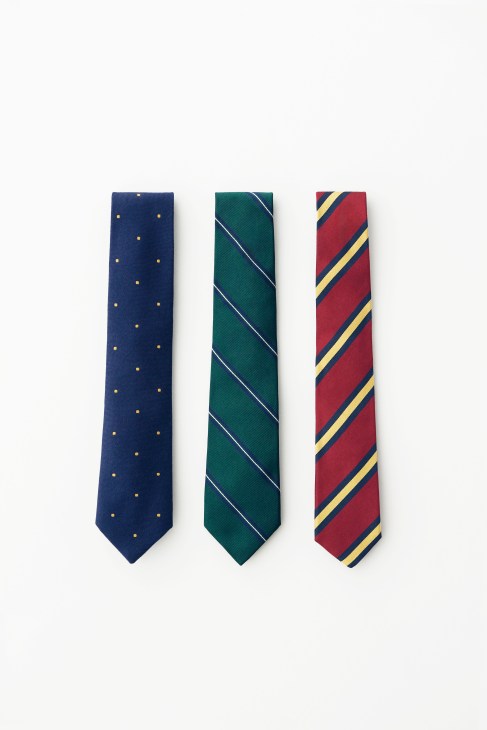 Three neckties displayed vertically: navy with gold dots, green with diagonal stripes, and burgundy with gold and navy stripes.