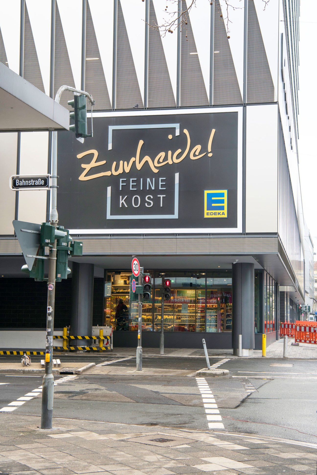 Zurheide Feine Kost supermarket exterior with signage and Edeka branding on Crown building in Düsseldorf.