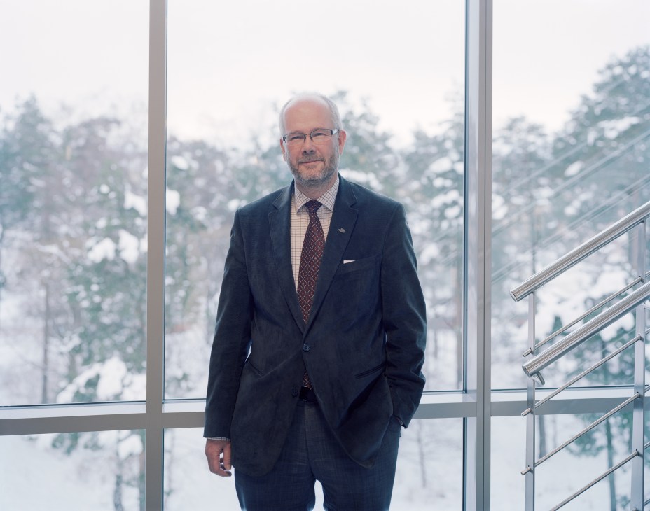 Lars Ekedahl, vice chancellor of Väst university, standing by large windows overlooking a snowy landscape.