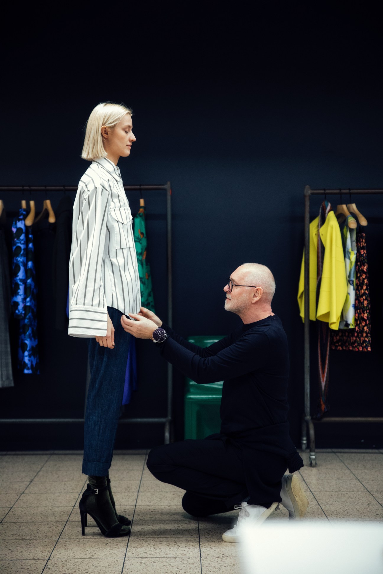Co-founder Jörg Ehrlich adjusts a striped blouse on model Julia during a fitting at the Odeeh studio.