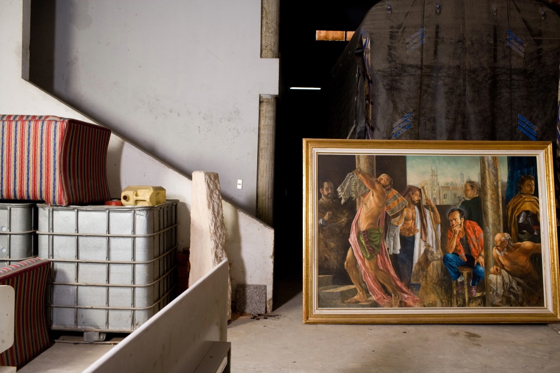 Confiscated items stored in warehouse including striped cushions, metalware, and a framed religious painting.