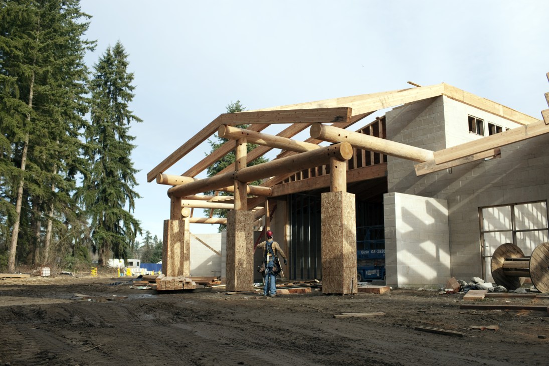 Construction site of the new Tulalip Museum with wooden structural framing and concrete block walls under development.