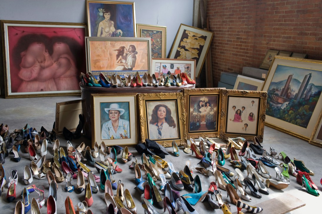 Confiscated shoes and portraits of drug trafficker La Monita Retrechera displayed in a warehouse awaiting auction.
