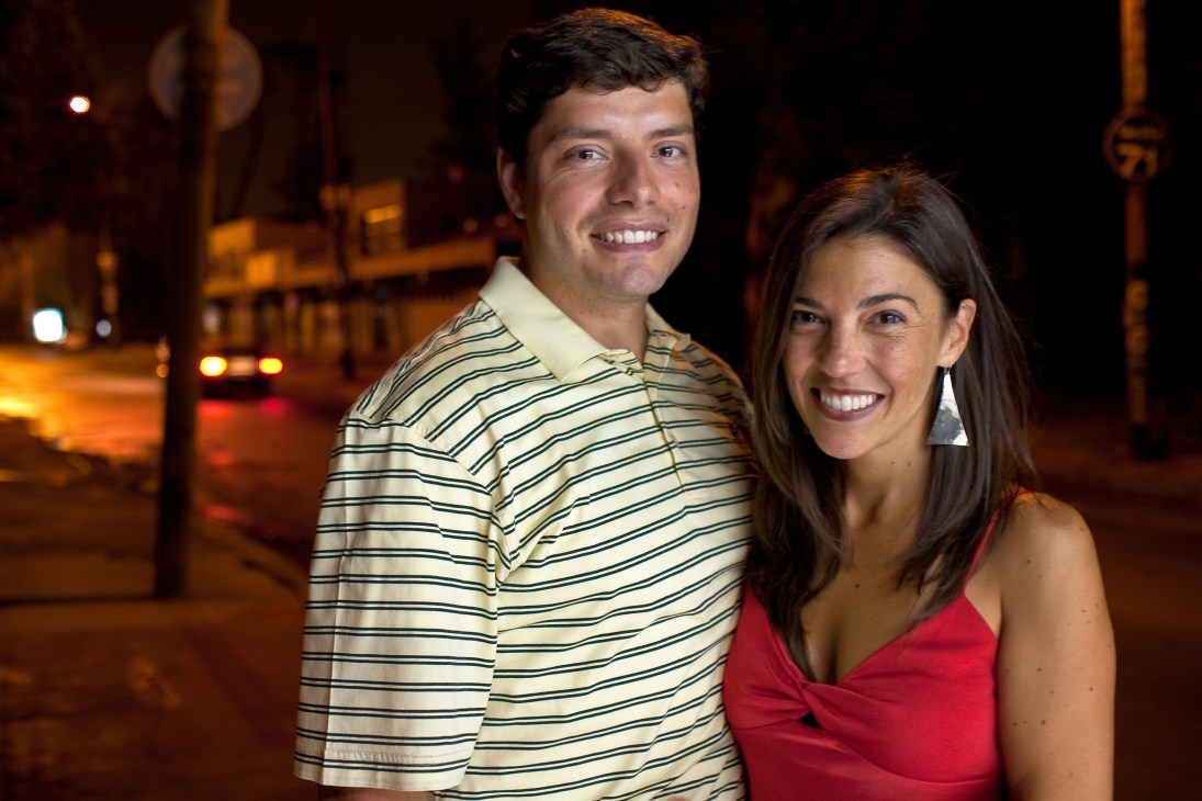 Expats Andres Vilegas and his wife Leigh Miller smiling on a Montevideo street at night.