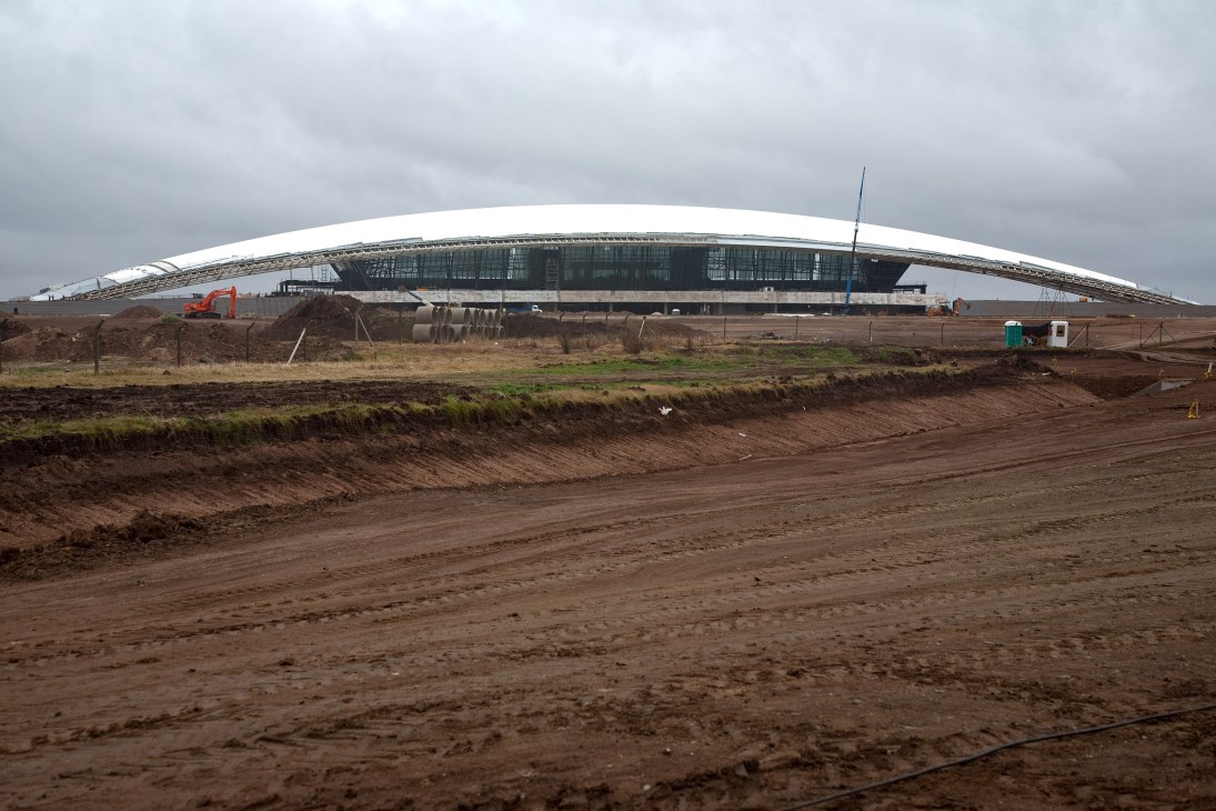 New Carrasco International Airport under construction with curved white roof and excavated grounds.