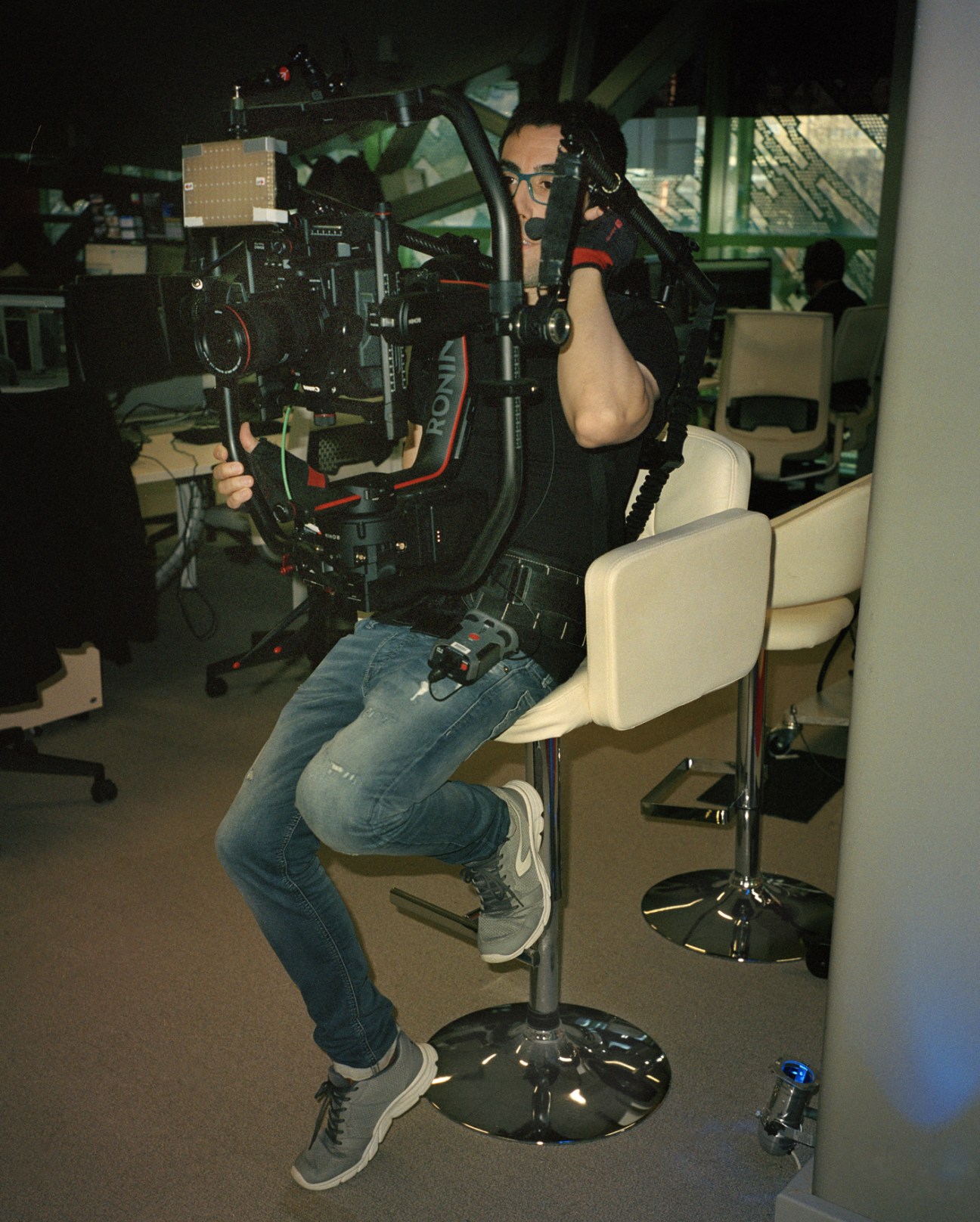 Cameraman operating professional video equipment in a studio control room.