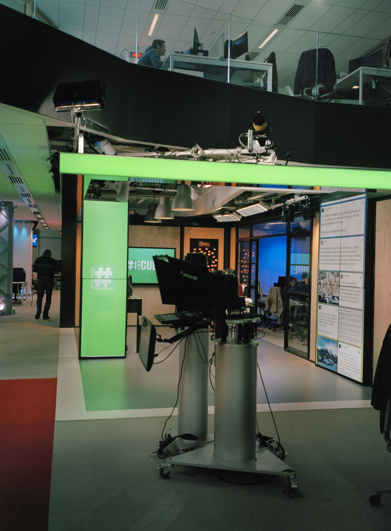Euronews's social media desk The Cube featuring a black camera mounted on a silver pedestal in a modern newsroom studio with green branding.