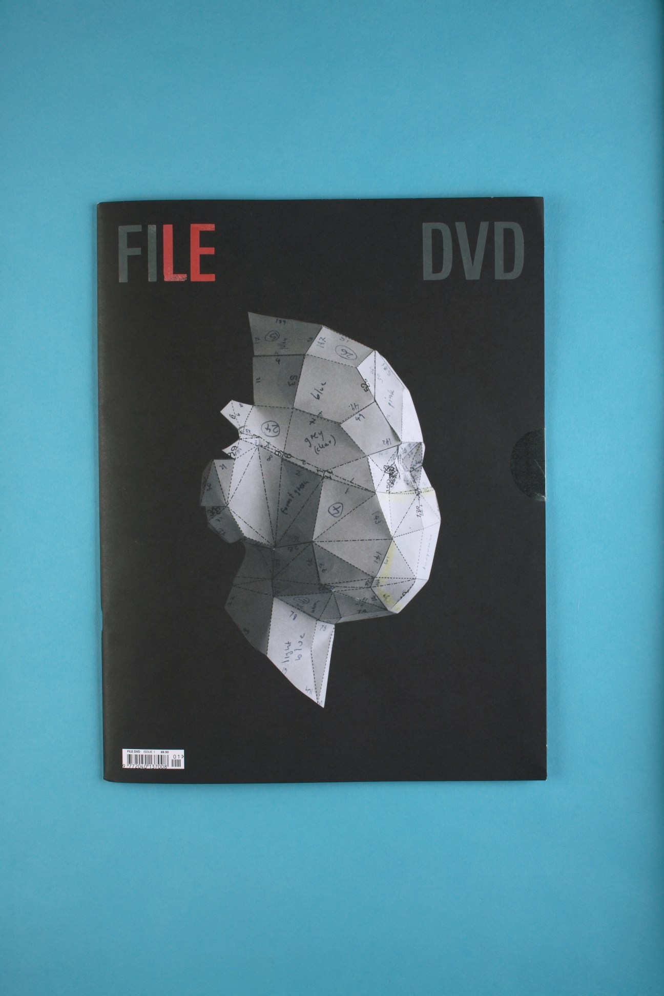 File magazine cover featuring geometric head illustration with DVD included on blue background.