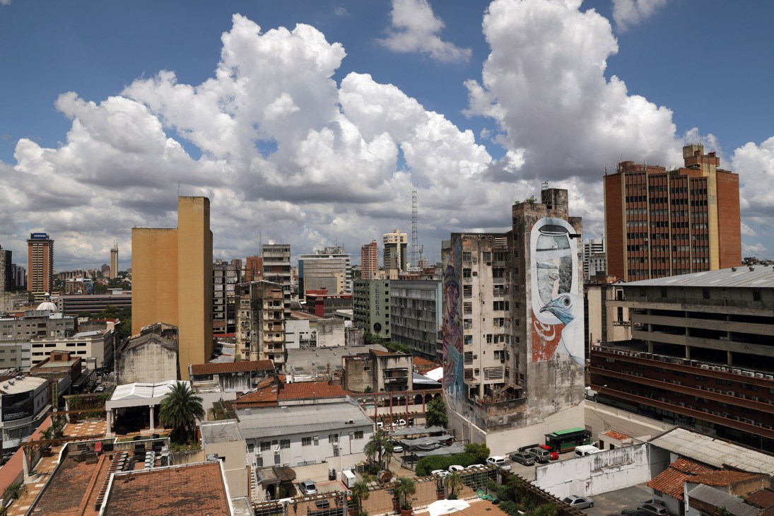Downtown Asunción cityscape with tall buildings, blue sky and white clouds.