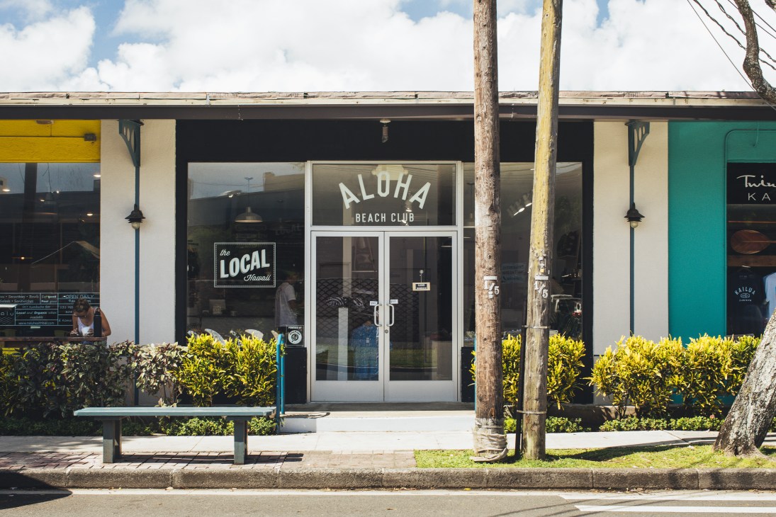 Aloha Beach Club storefront in Kailua, Hawaii with white doors and yellow signage.
