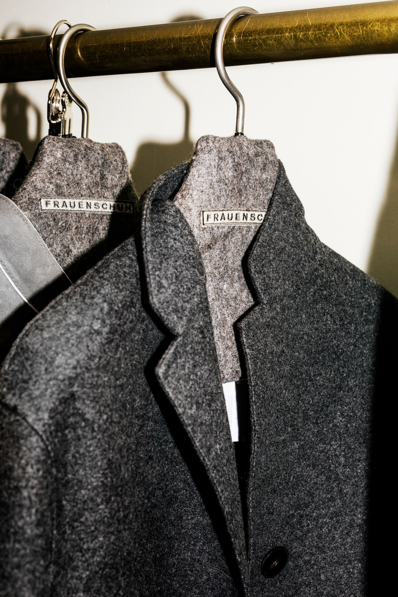 Gray felted wool jackets hanging on hangers with Frauenschuh brand labels
