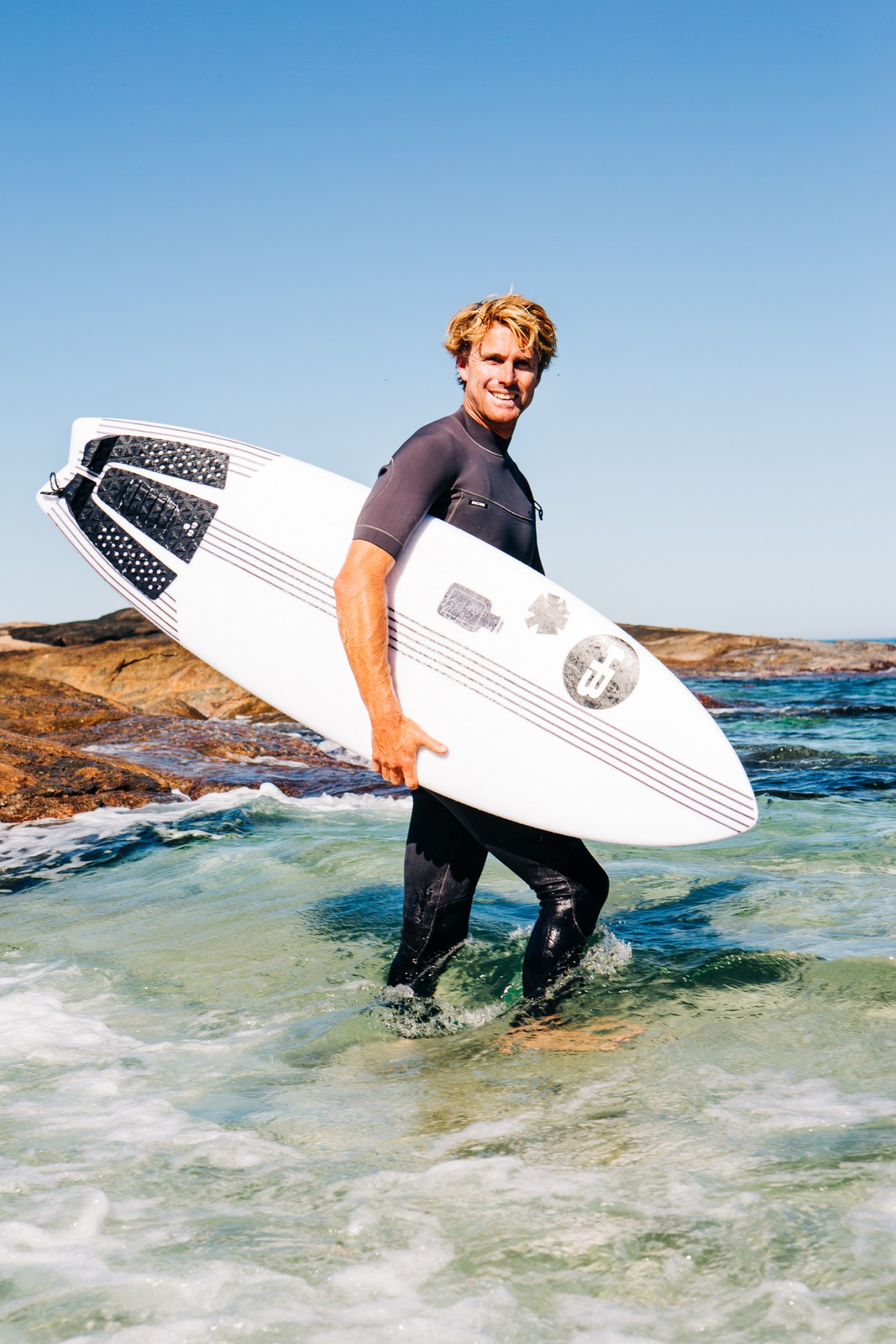 Josh Castleden heading out with surfboard at Margaret River beach