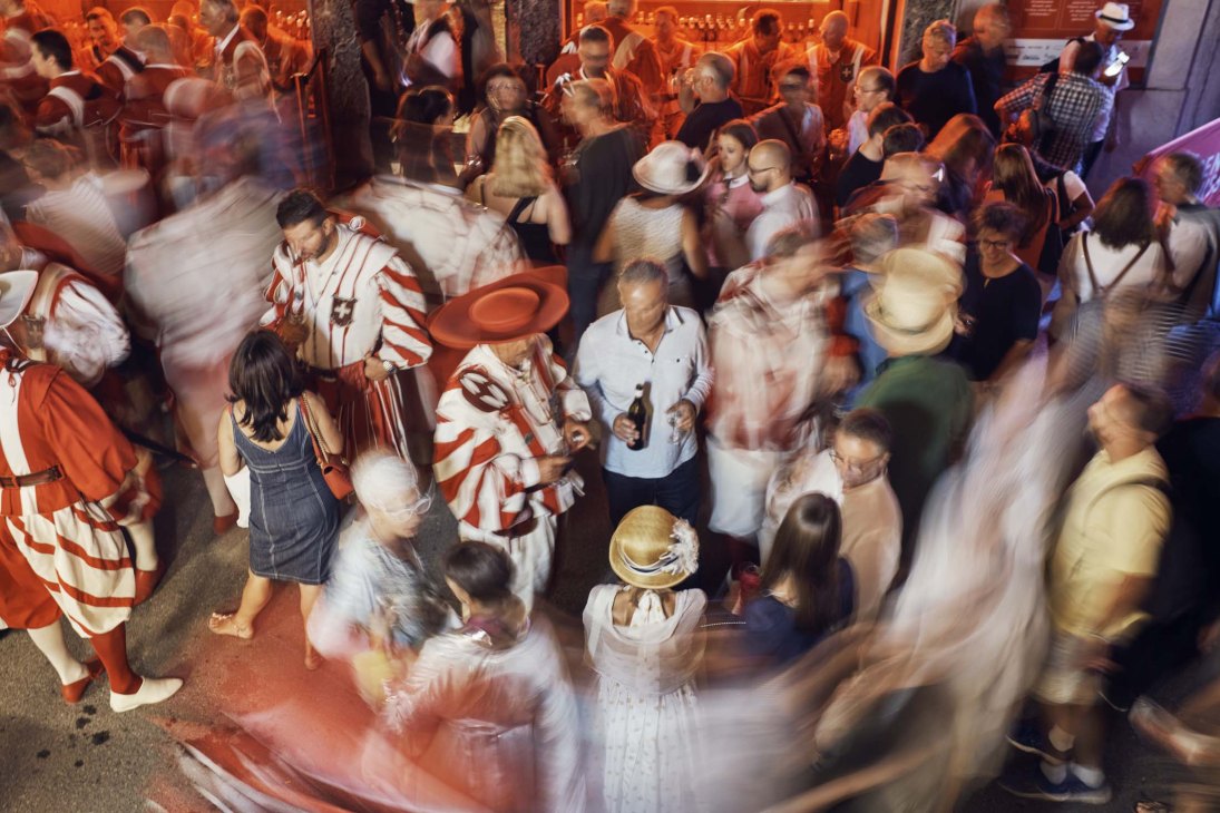 Crowded festival celebration with people in colorful costumes dancing and celebrating in motion blur