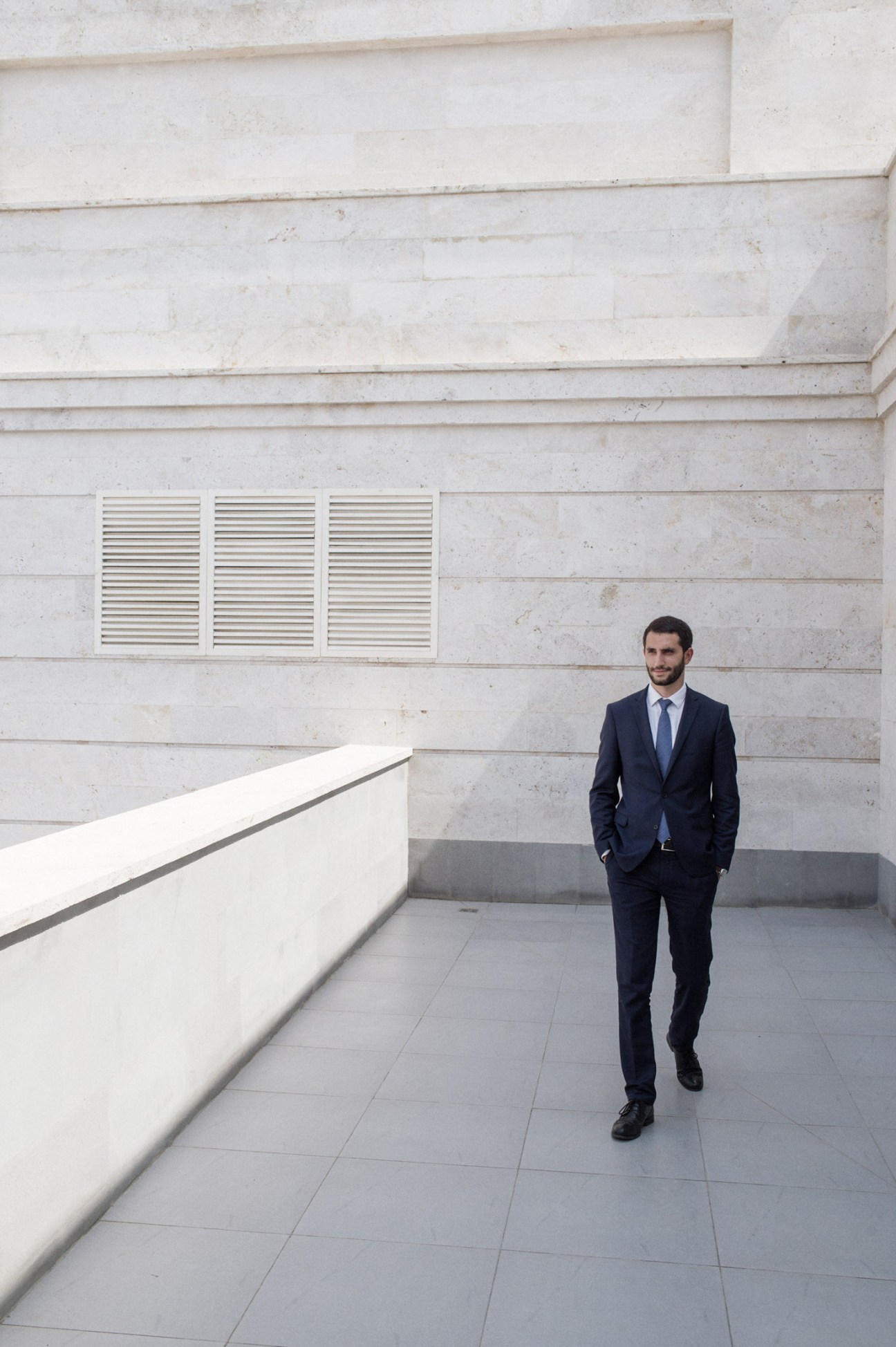 Ruben Rubinyan, deputy minister of foreign affairs, walking through a modern corridor with white walls.