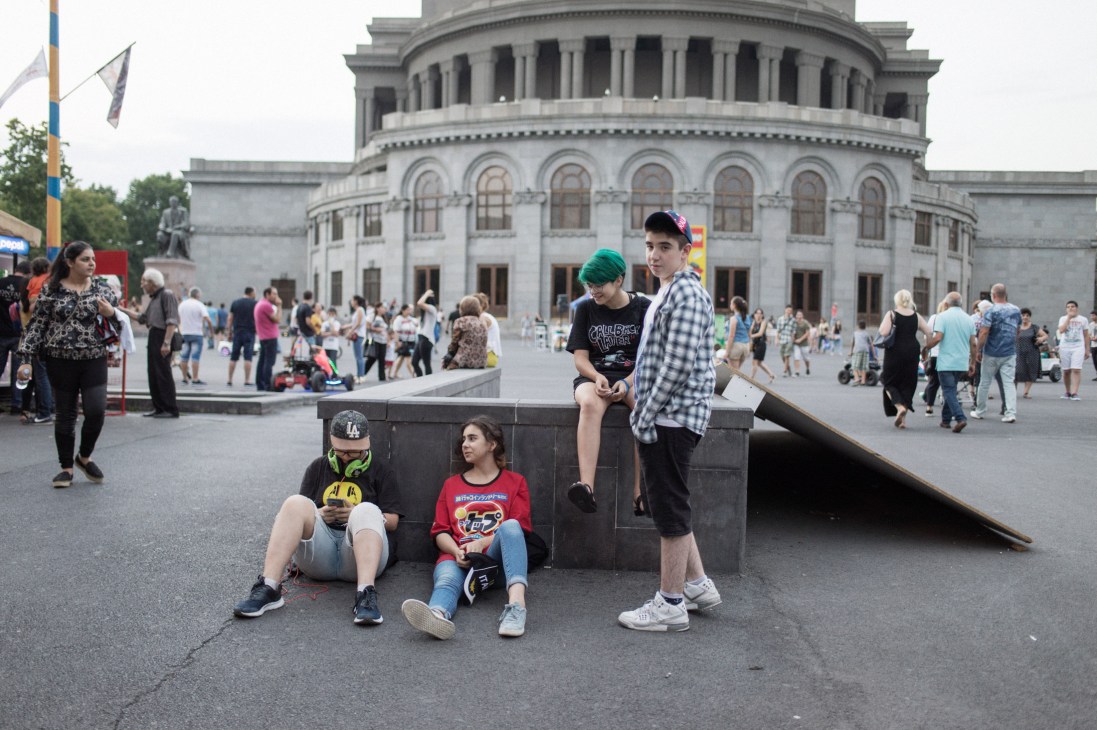 Young people hanging out in Republic Square, Yerevan, with the National Assembly building in the background.