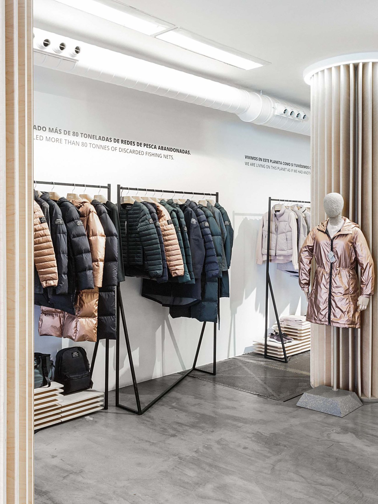 Ecoalf showroom displaying sustainable jackets and outerwear made from recycled materials on clothing racks.