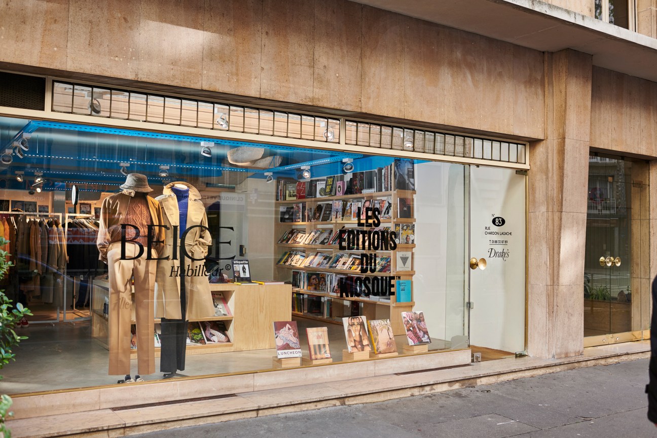 Beige Habilleur menswear boutique storefront in Paris with large window display featuring mannequins in tailored clothing and magazines.