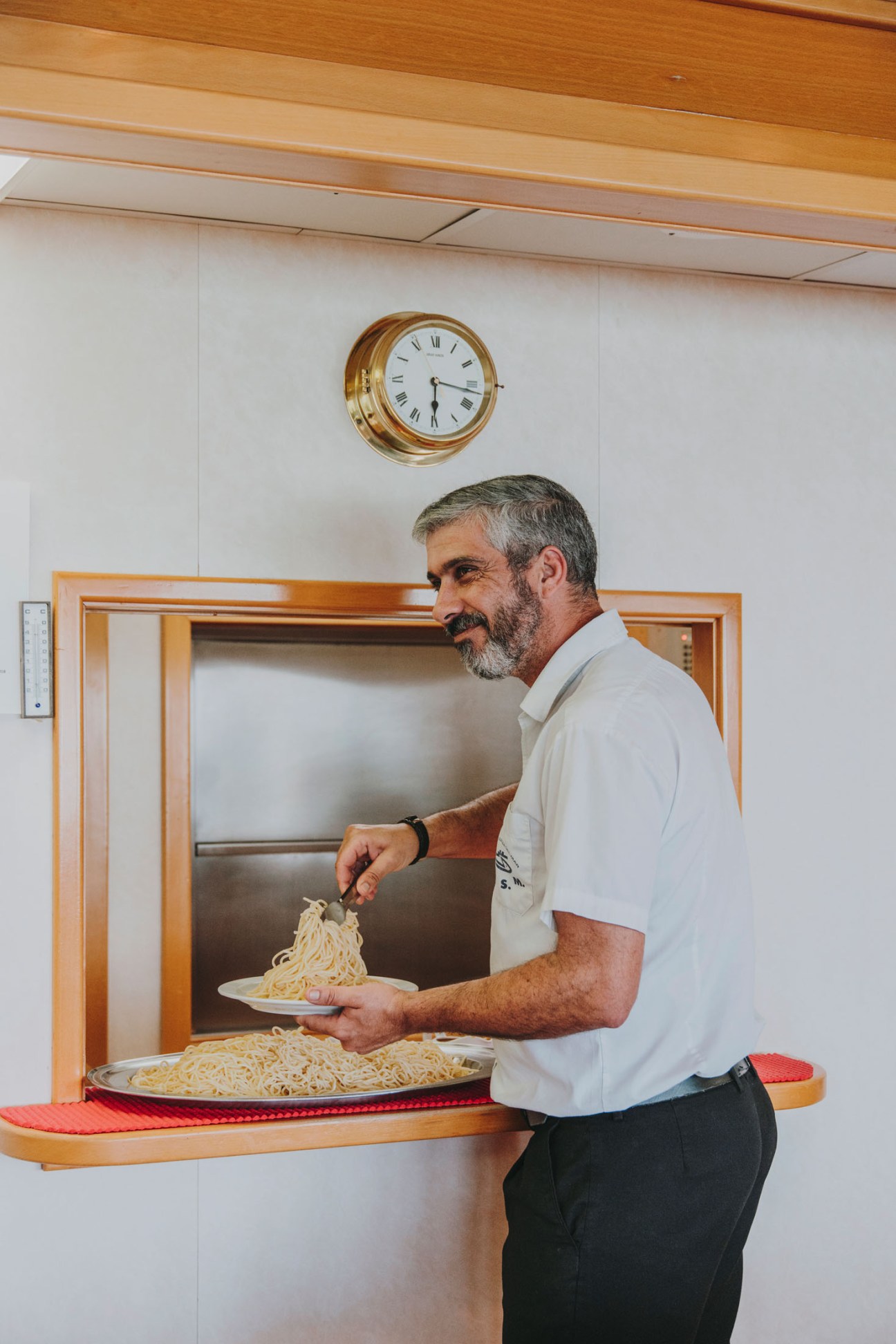 Chef Miguel Ángel García Medina serves pasta in the officers' mess hall aboard the Esperanza del Mar.