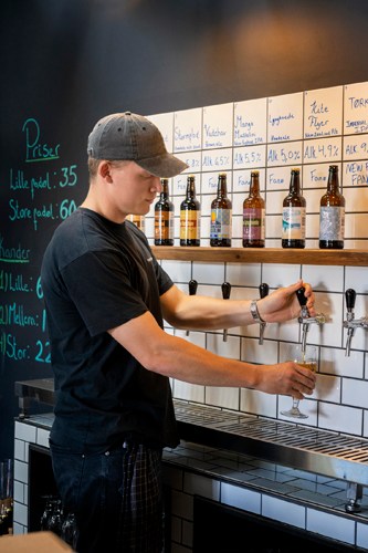 Staff member pouring beer from tap at Fanø Bryghus brewery